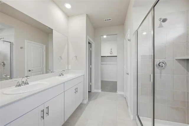 a spacious bathroom with a double vanity sink mirror and shower