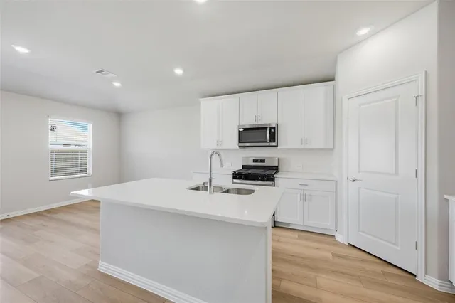 a kitchen with stainless steel appliances a microwave sink refrigerator and cabinets