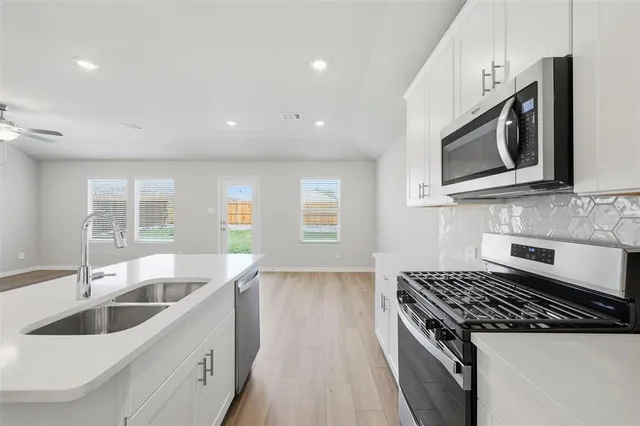 a kitchen with granite countertop a sink and stove top oven