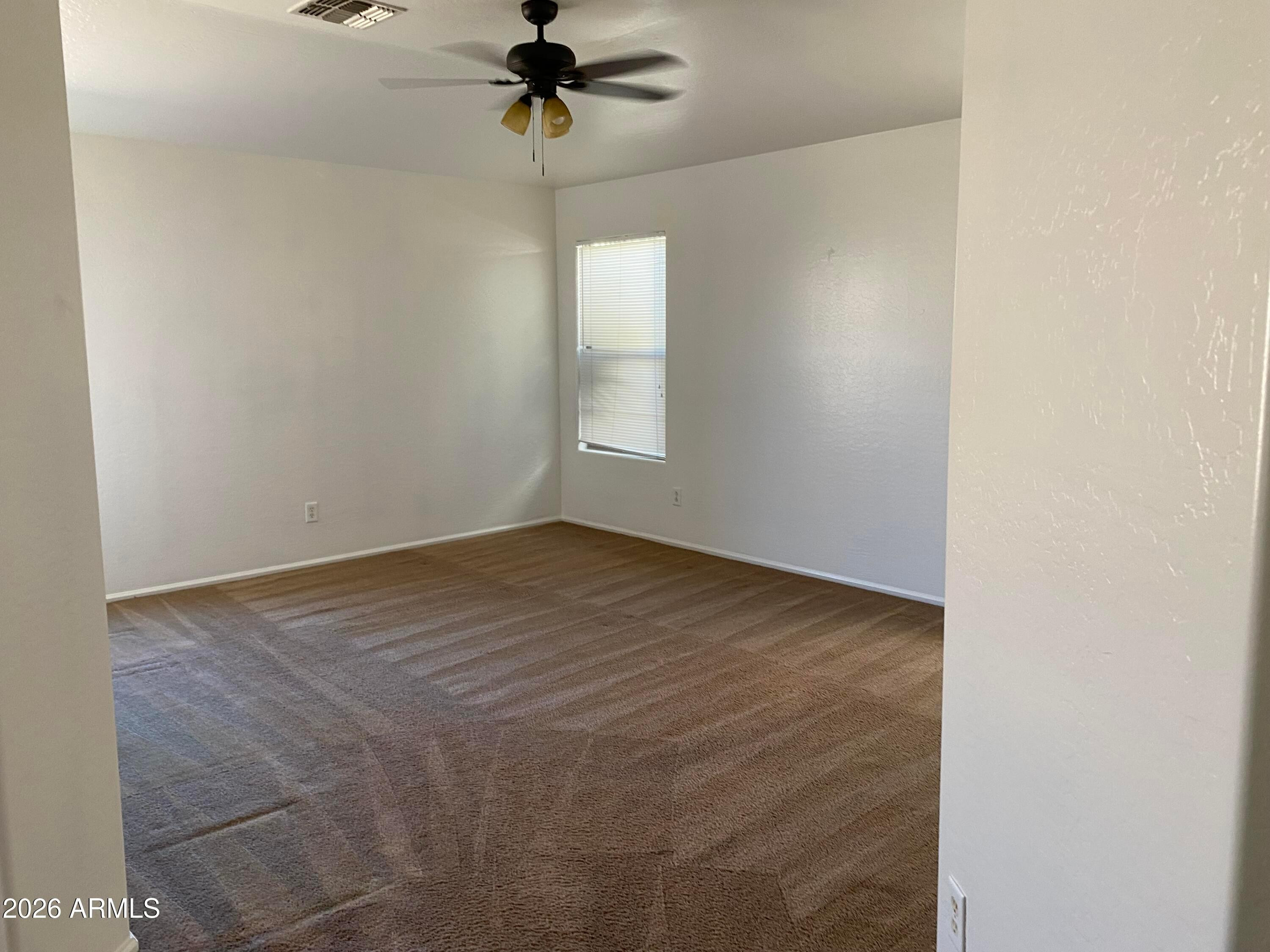 9124 West Heber Road Tolleson, AZ 85353 - Photo 13 of 26 a view of an empty room with a chandelier fan