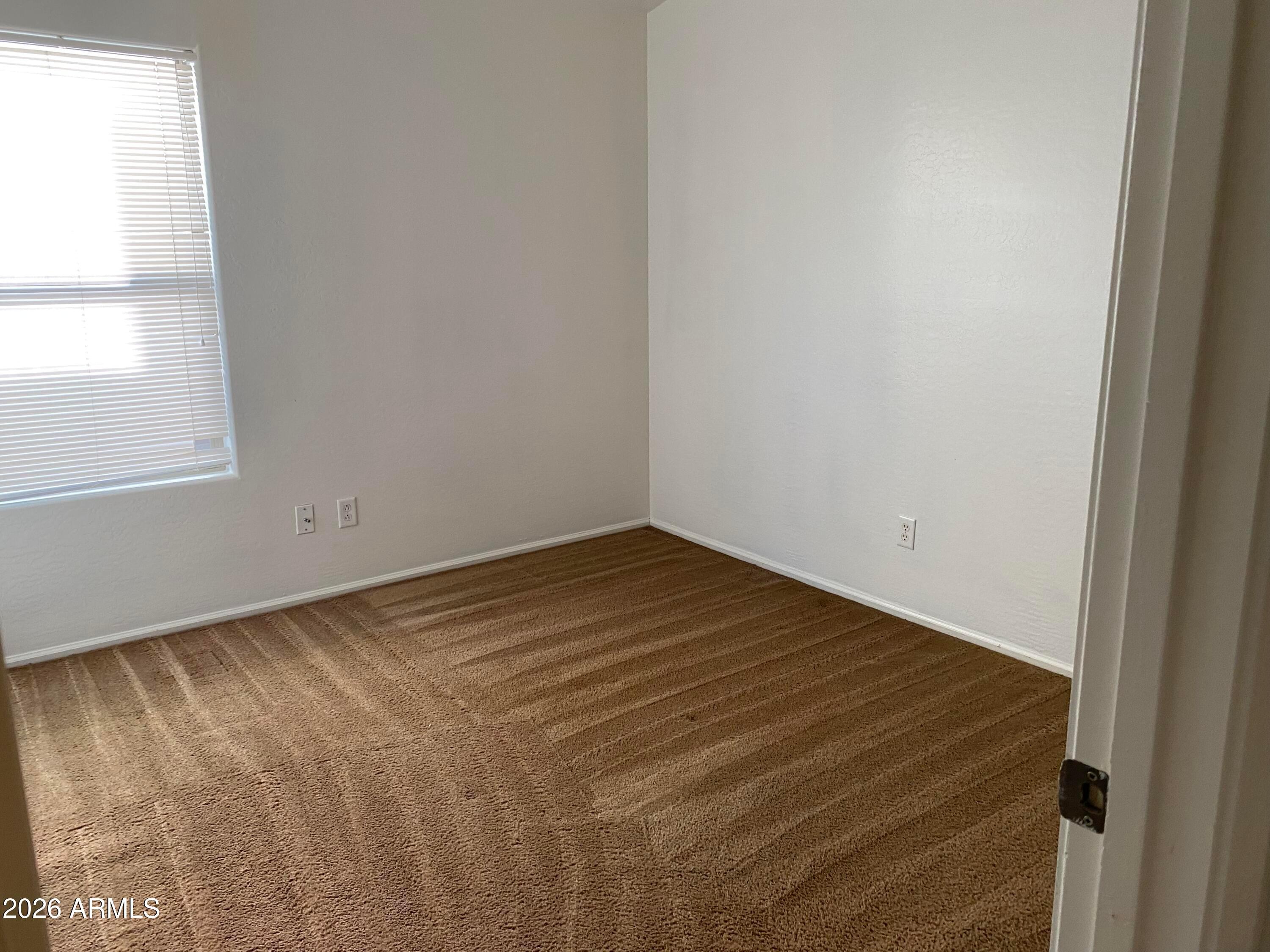 9124 West Heber Road Tolleson, AZ 85353 - Photo 21 of 26 a view of empty room with wooden floor and fan