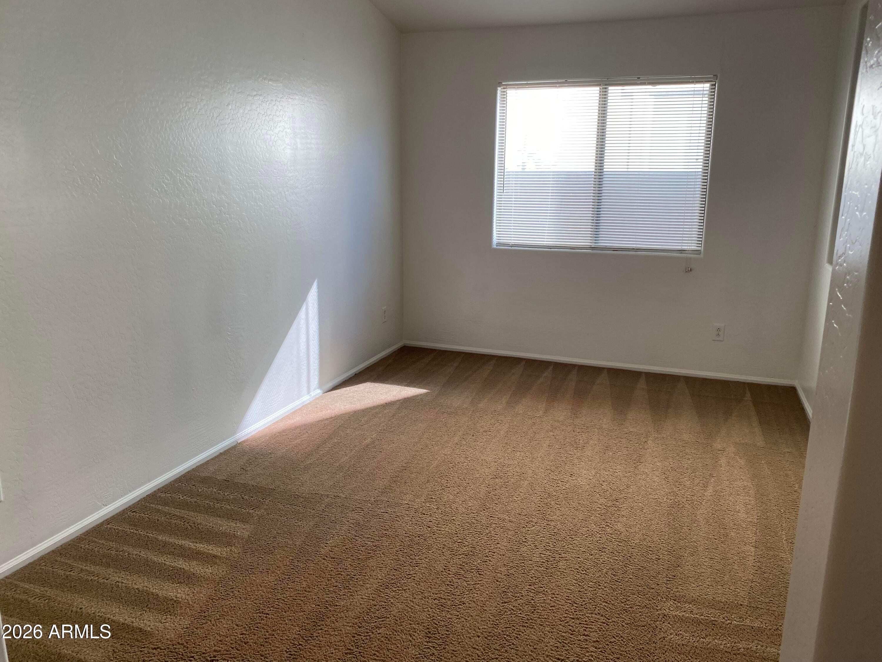 9124 West Heber Road Tolleson, AZ 85353 - Photo 6 of 26 an empty room with a window