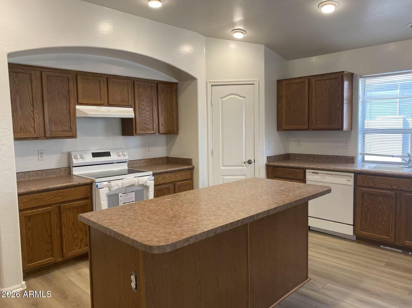 9124 West Heber Road Tolleson, AZ 85353 - Photo 9 of 26 a kitchen with granite countertop a stove and a sink
