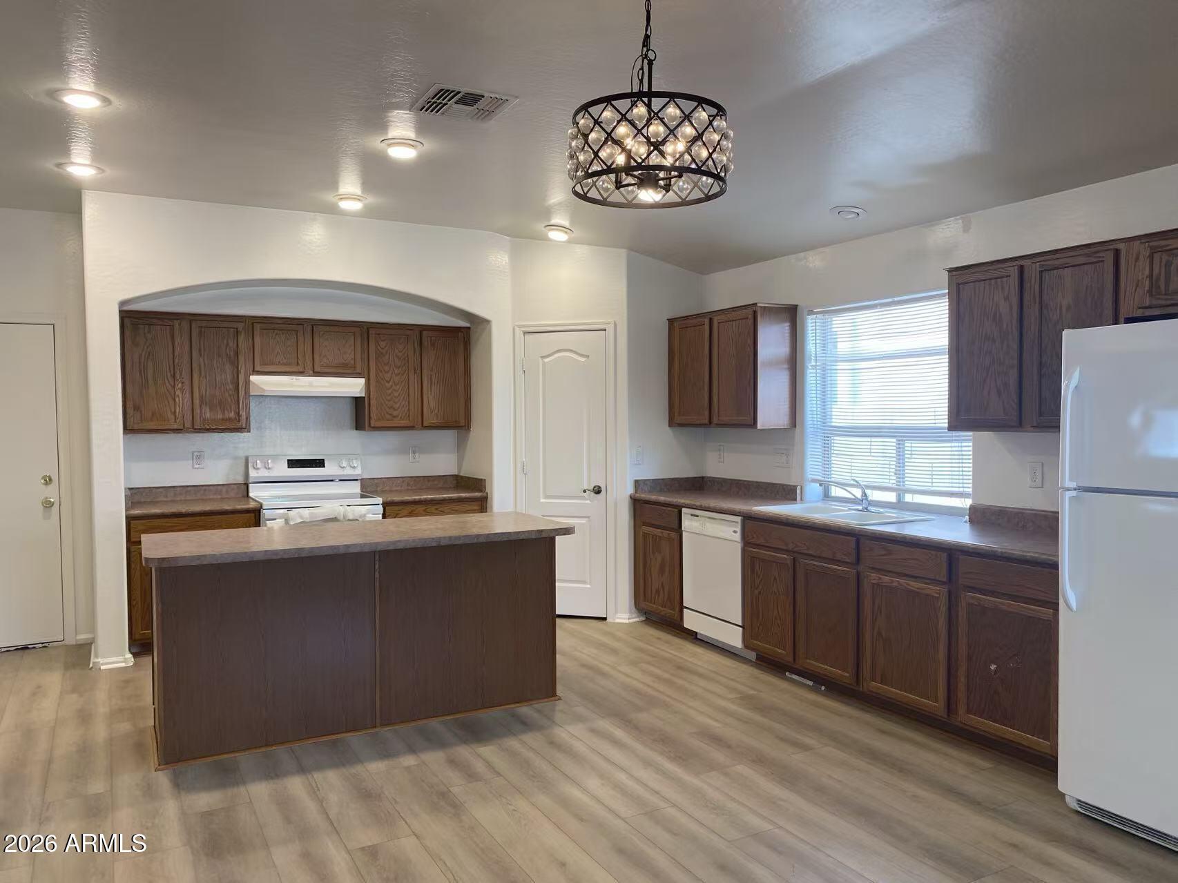9124 West Heber Road Tolleson, AZ 85353 - Photo 10 of 26 a large kitchen with stainless steel appliances wooden floors a stove and a refrigerator