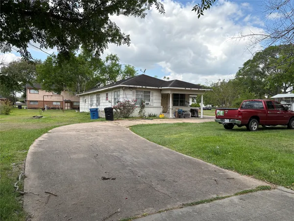 a front view of a house with a garden and trees