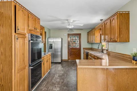 a kitchen with stainless steel appliances granite countertop a sink and a refrigerator