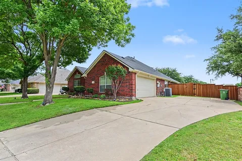 a view of a house with a yard and large tree