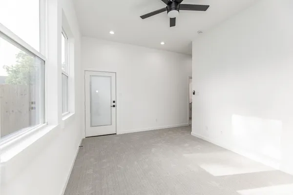 an empty room with a ceiling fan and window