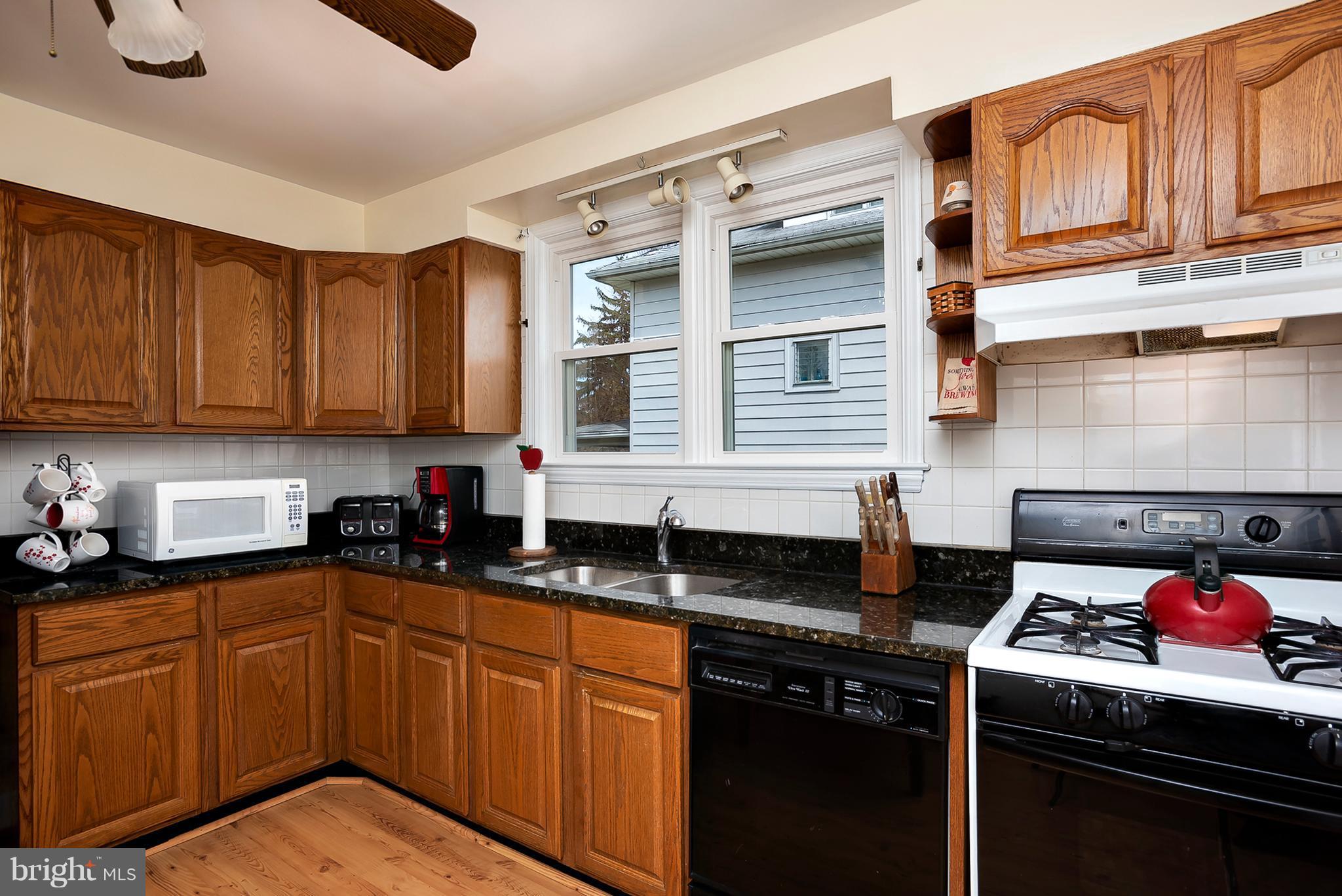618 Coleraine Road Baltimore, MD 21229 - Photo 9 of 27 a kitchen with granite countertop a sink stove and cabinets