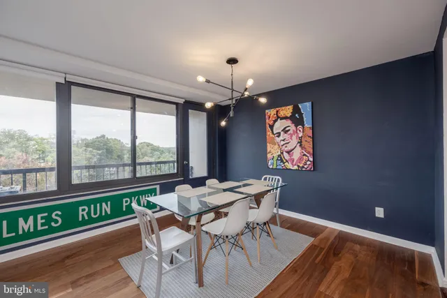 a dining room with furniture a rug a chandelier and wooden floor