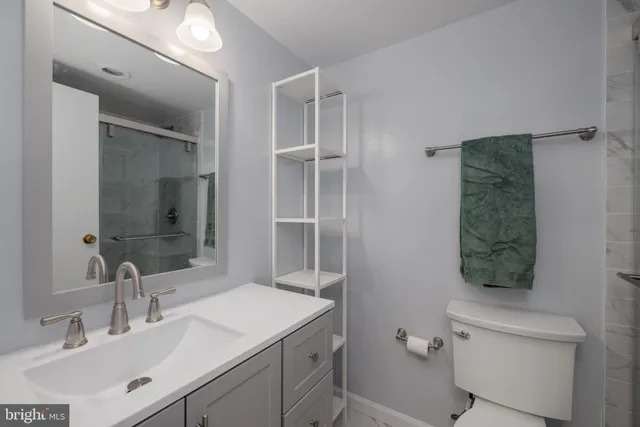 a bathroom with a sink toilet vanity and shower