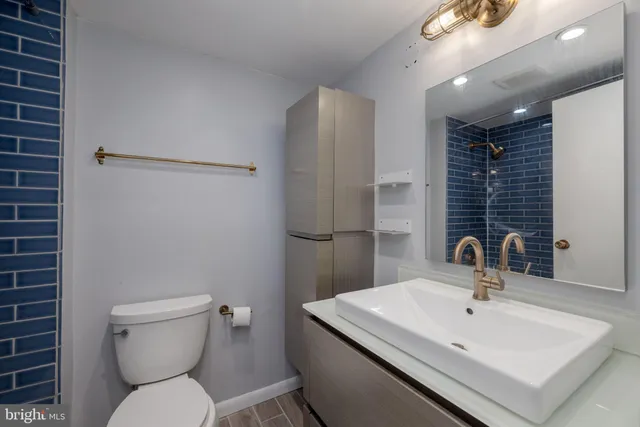 a bathroom with a sink a toilet and a mirror