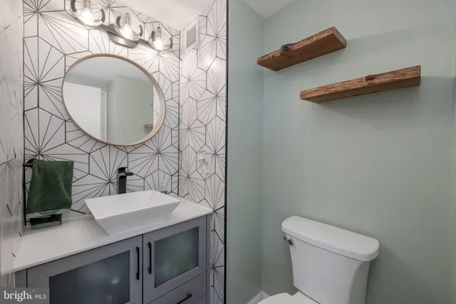 a bathroom with a sink mirror vanity and toilet