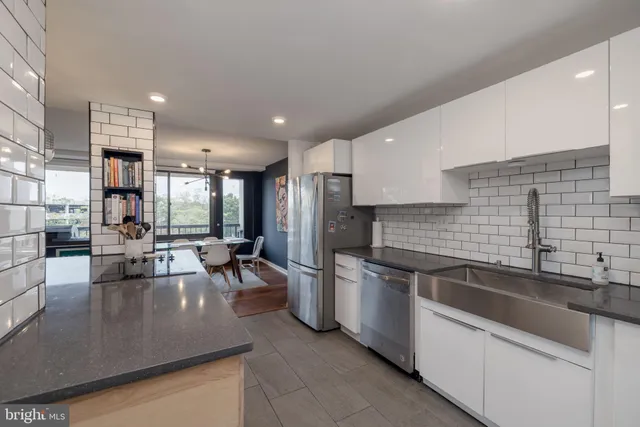 a kitchen with stainless steel appliances granite countertop a sink a stove and a refrigerator