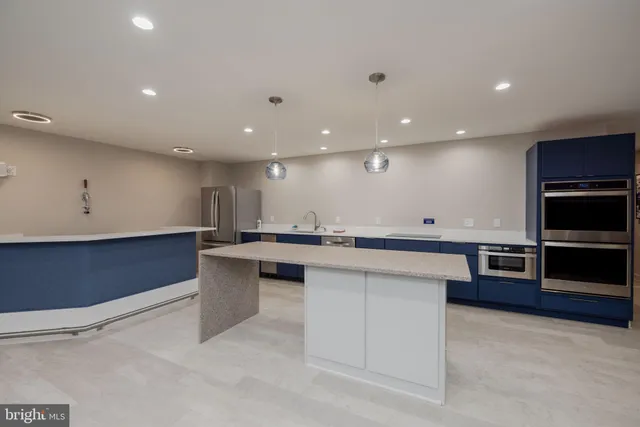 a large kitchen with stainless steel appliances a large counter top