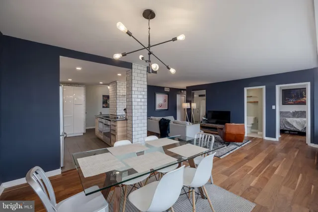 a living room with furniture a flat screen tv and kitchen view