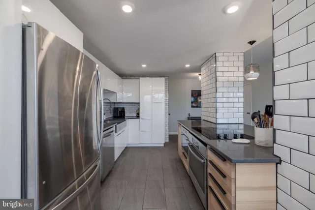 a kitchen with stainless steel appliances granite countertop a refrigerator and a stove