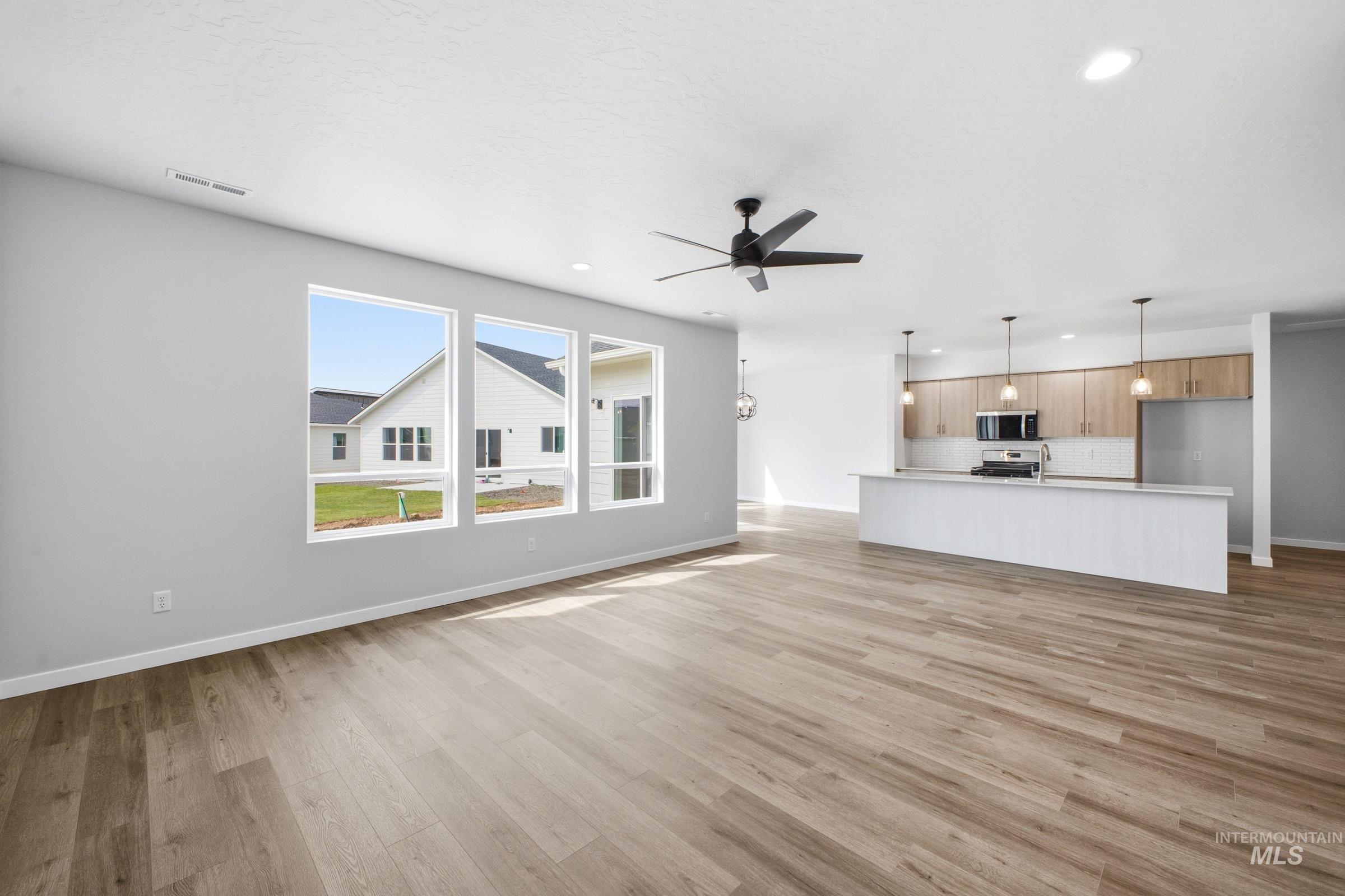5293 South Memory Avenue Meridian, ID 83642 - Photo 12 of 24 Unfurnished living room featuring a ceiling fan, light wood-type flooring, and recessed lighting