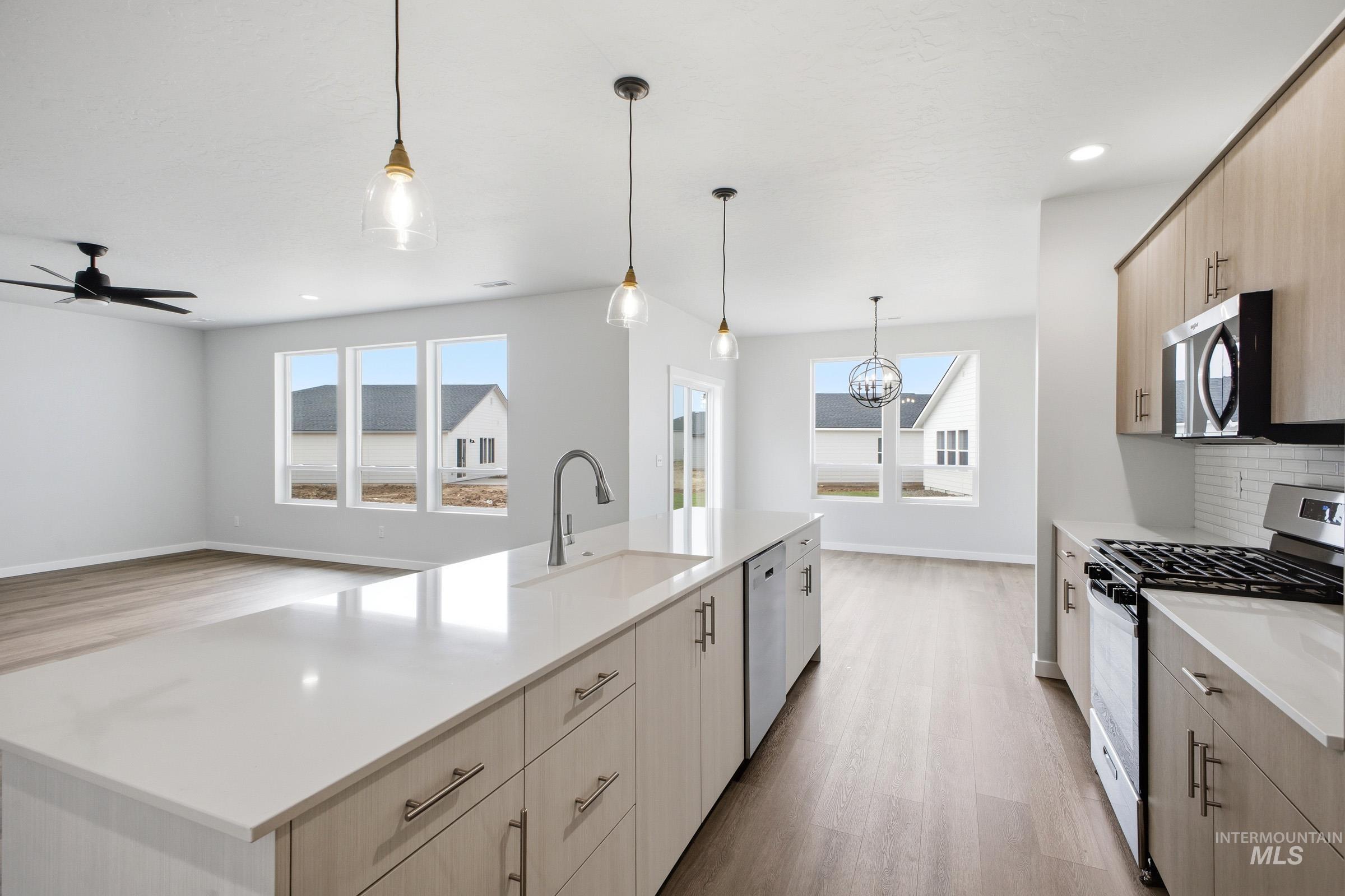 5293 South Memory Avenue Meridian, ID 83642 - Photo 6 of 24 Kitchen with stainless steel appliances, a kitchen island with sink, light wood-style flooring, and light wood finish cabinets