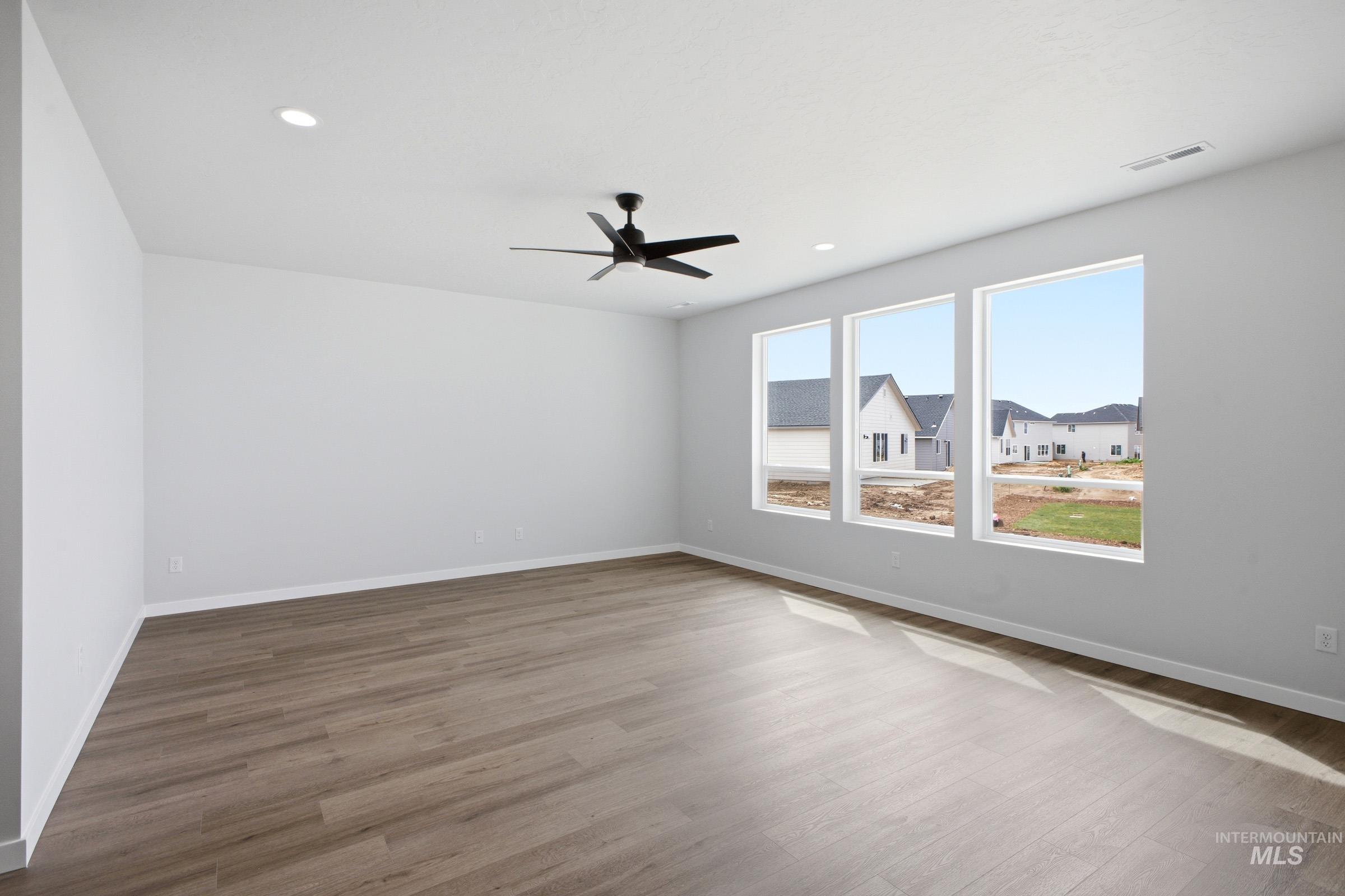 5293 South Memory Avenue Meridian, ID 83642 - Photo 10 of 24 Empty room with wood finished floors, a ceiling fan, and recessed lighting