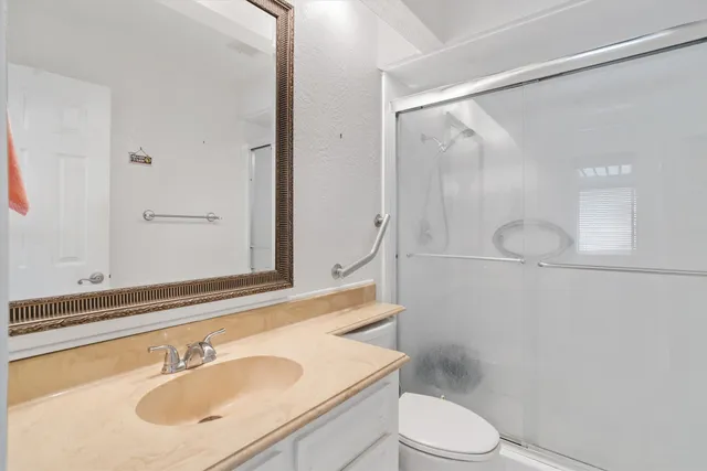 a bathroom with a sink toilet vanity and shower