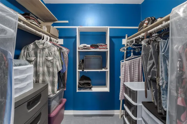 a view of walk in closet with clothes and shoes