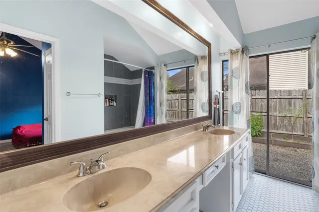 a bathroom with a granite countertop sink and a large mirror