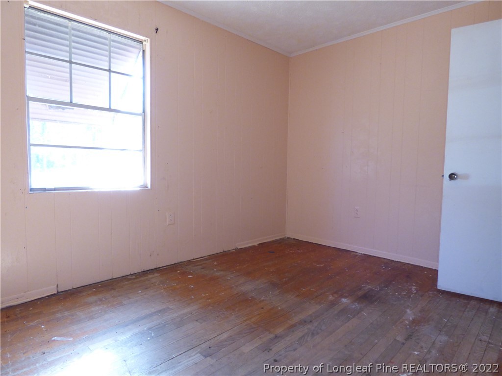 6690 Turnpike Road Raeford, NC 28376 - Photo 8 of 12 an empty room with wooden floor and windows