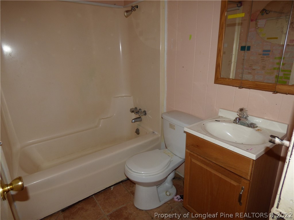6690 Turnpike Road Raeford, NC 28376 - Photo 9 of 12 a bathroom with a sink toilet and shower