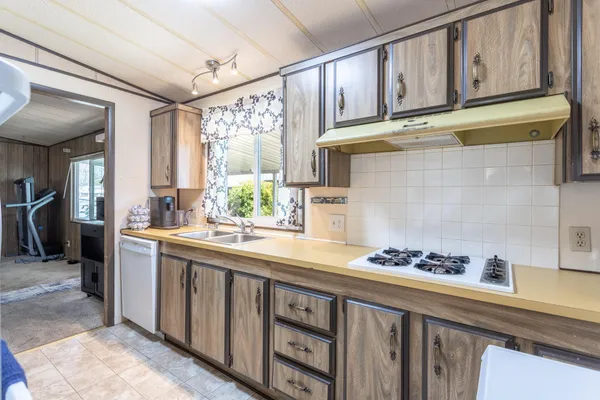 a kitchen with stainless steel appliances granite countertop a sink stove and cabinets