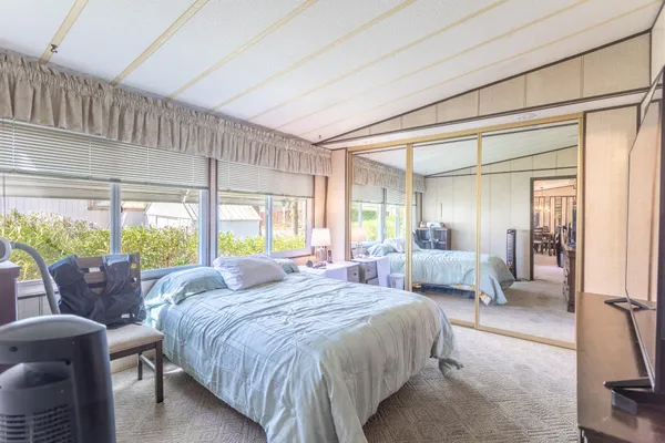 a large bedroom with a bed and large windows