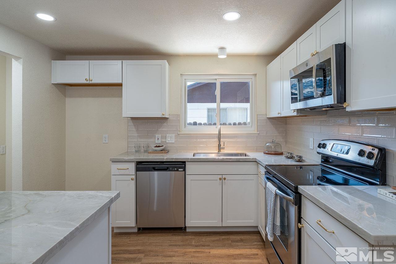 2857 Jake Street Reno, NV 89502 - Photo 5 of 22 a kitchen with stainless steel appliances granite countertop a sink stove and cabinets