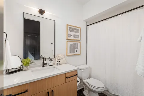 a bathroom with a granite countertop sink mirror vanity and toilet