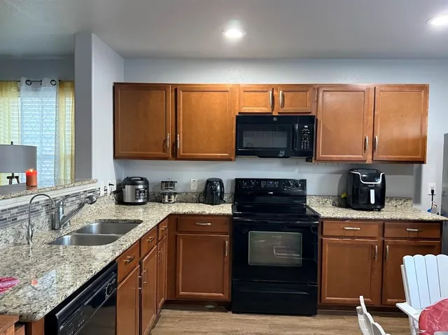 a kitchen with a sink stove top oven and cabinets