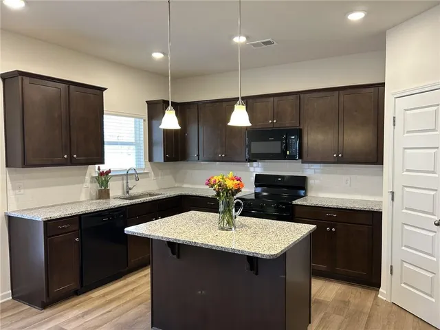 a kitchen with a sink cabinets and wooden floor