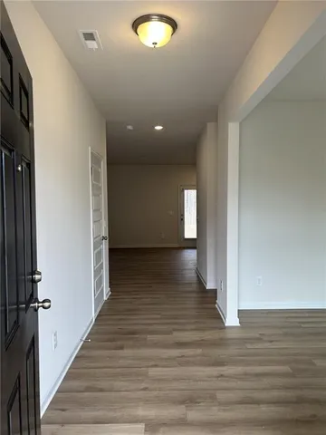 a view of a hallway with wooden floor