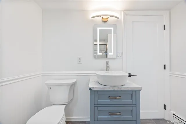 a bedroom with a bed and a dresser with wooden floor