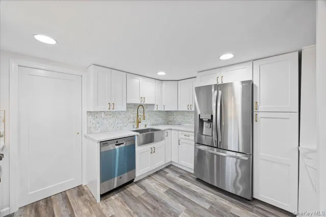 a kitchen with stainless steel appliances a refrigerator sink and cabinets