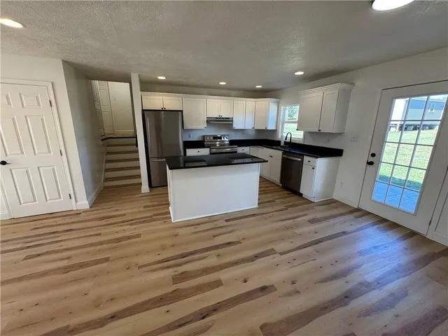 a view of kitchen with wooden floor and electronic appliances