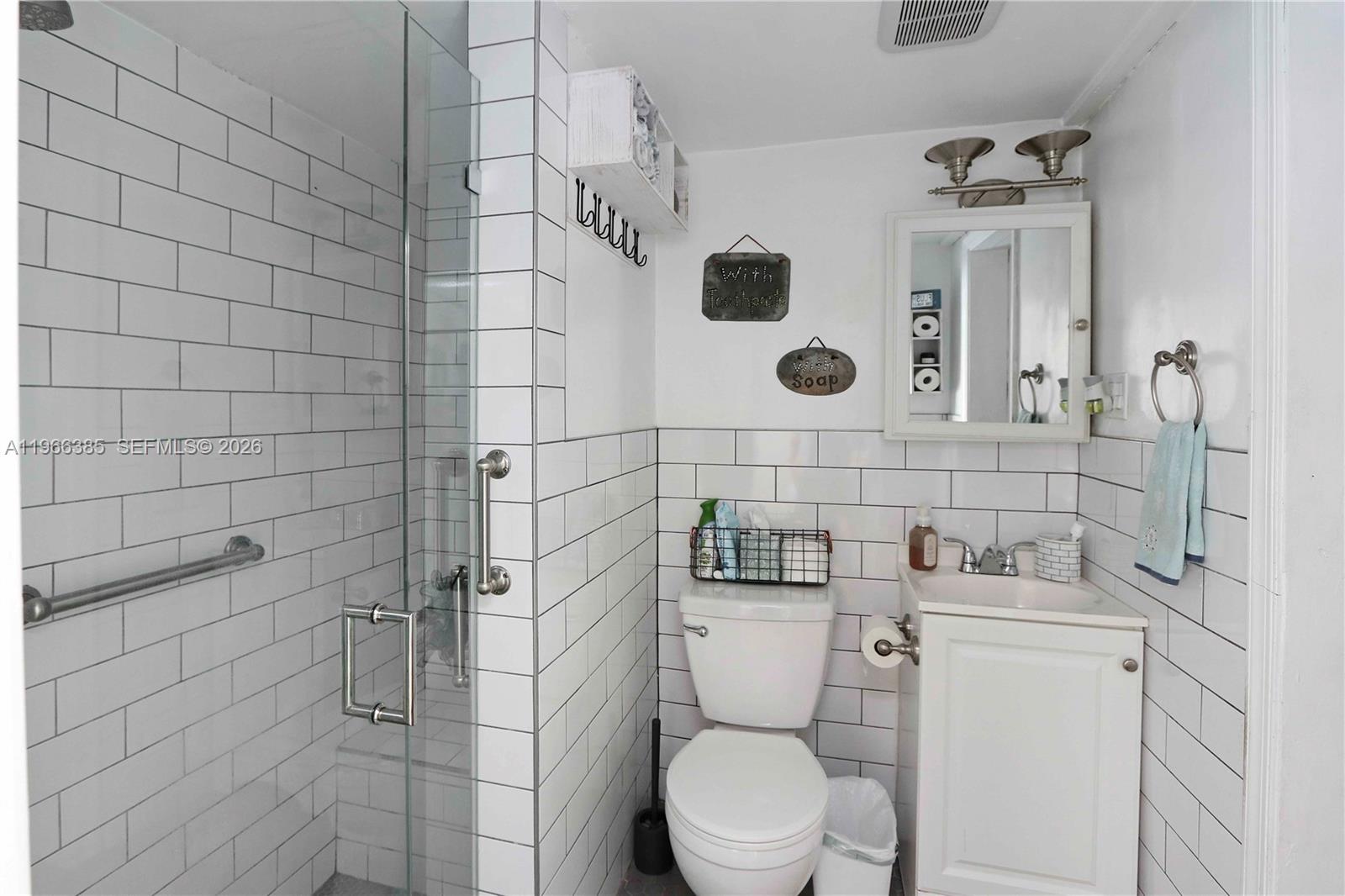 1221 Southwest 74th Court Miami, FL 33144 - Photo 24 of 42 a bathroom with a toilet sink and mirror