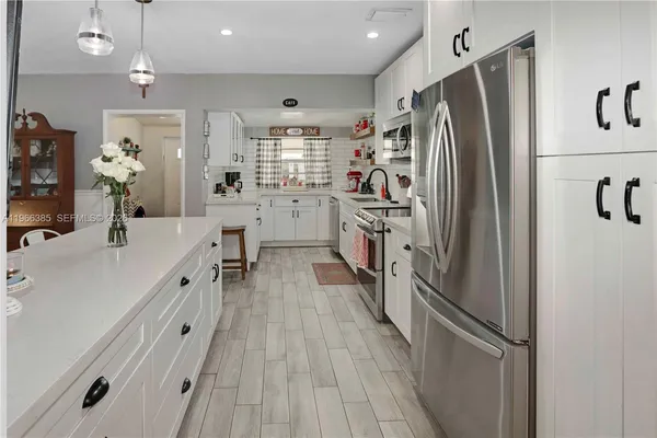 a kitchen with white cabinets and stainless steel appliances