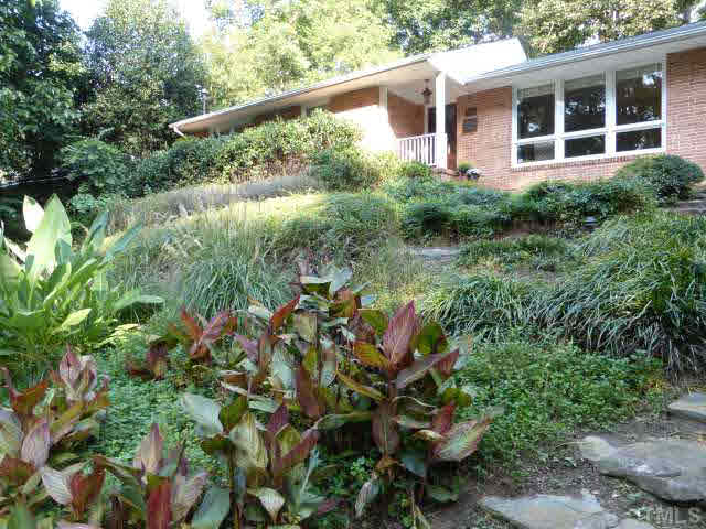 2516 Oxford Road Raleigh, NC 27608 - Photo 3 of 23 Native grasses, exotic plants and stone paths are part of the front yard created by a former owner, several times removed, architect Louis Cherry, with design input from David Brown, landscape architect.