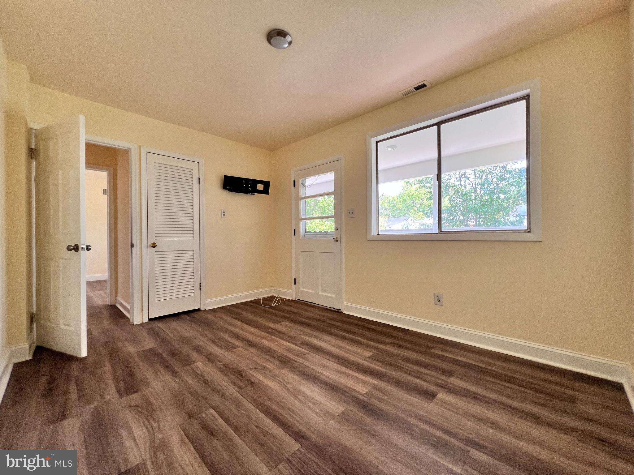 9227 Riggs Road Adelphi, MD 20783 - Photo 24 of 78 an empty room with wooden floor and windows