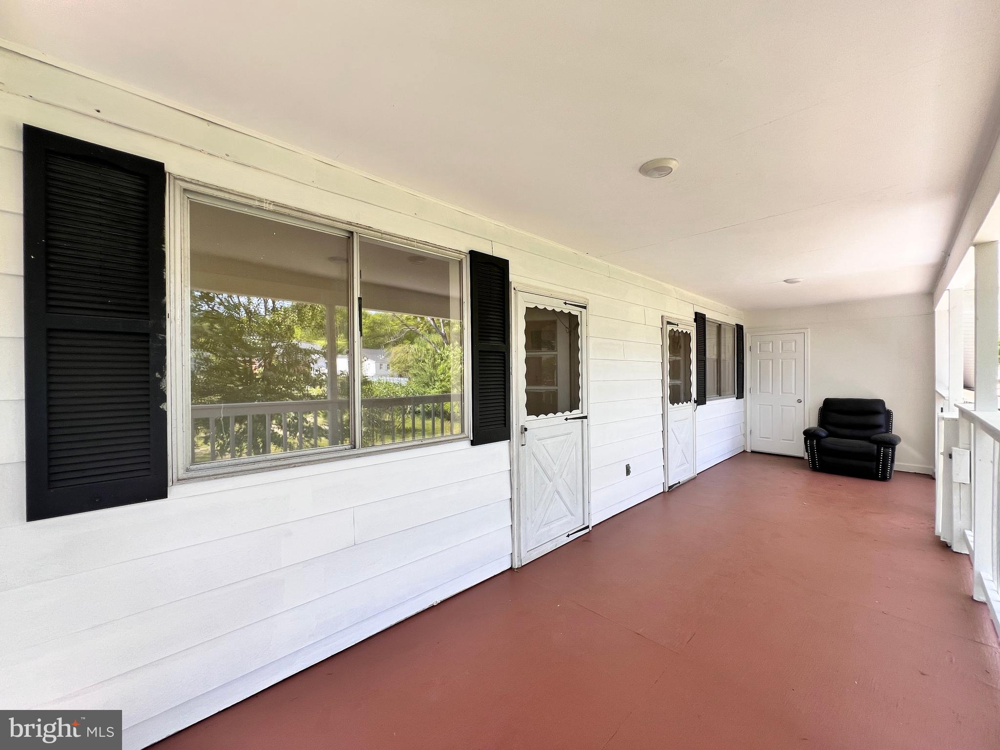 9227 Riggs Road Adelphi, MD 20783 - Photo 32 of 78 a large white room with a large window and a balcony wooden floor