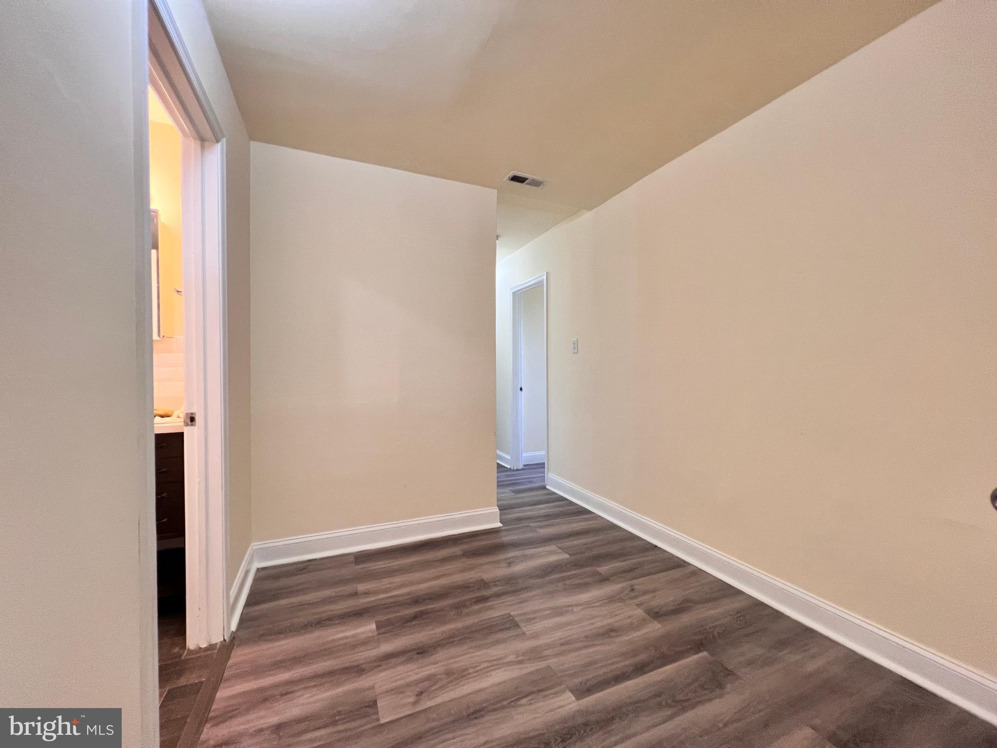 9227 Riggs Road Adelphi, MD 20783 - Photo 36 of 78 a view of an empty room with wooden floor and a window