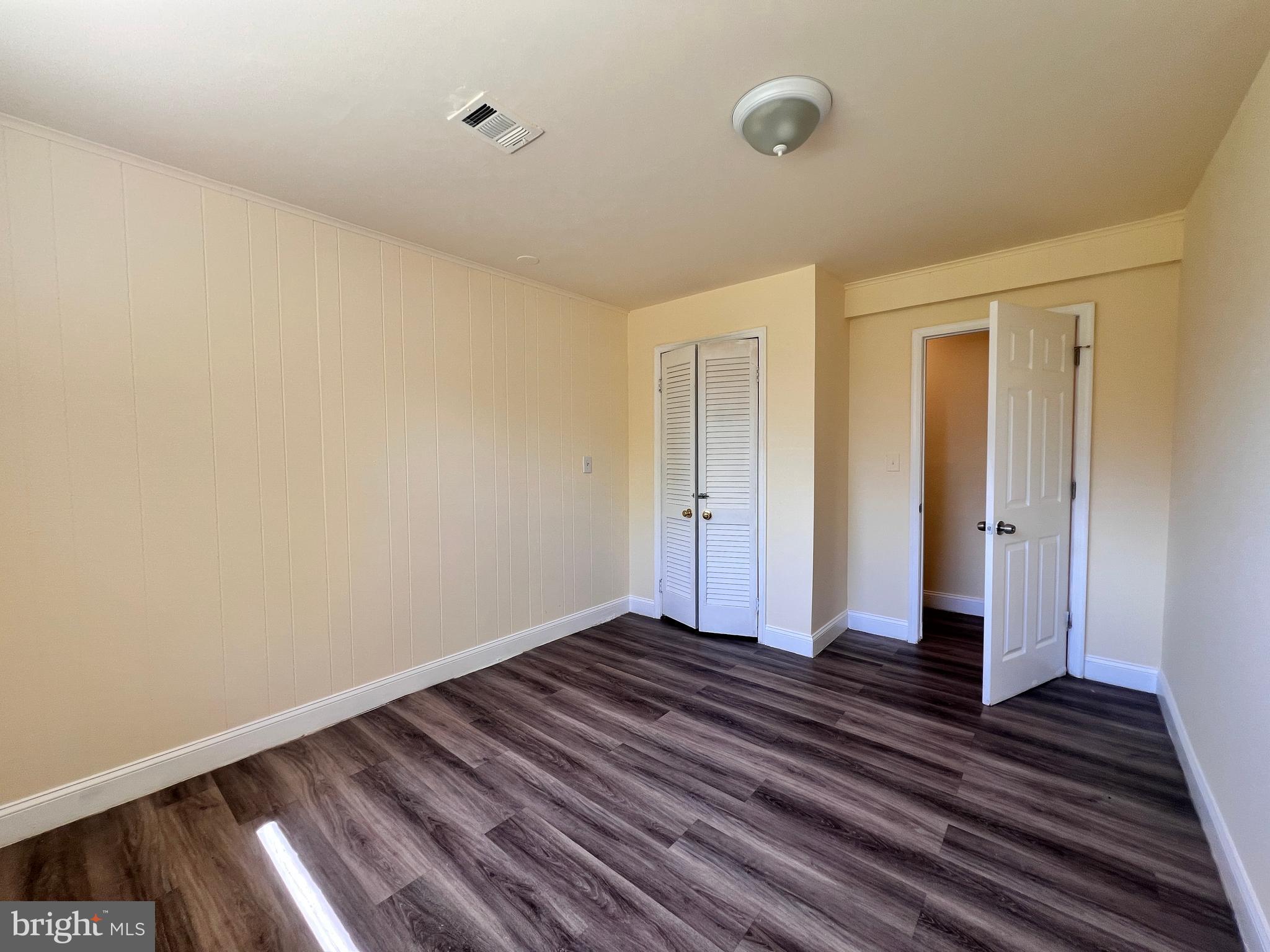 9227 Riggs Road Adelphi, MD 20783 - Photo 47 of 78 a view of an empty room with wooden floor and a window