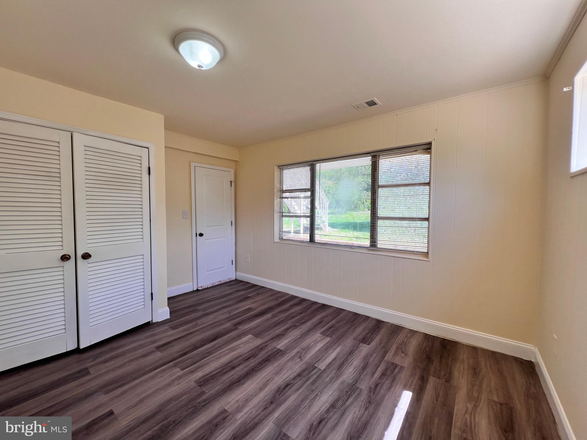9227 Riggs Road Adelphi, MD 20783 - Photo 50 of 78 a view of an empty room with wooden floor and a window
