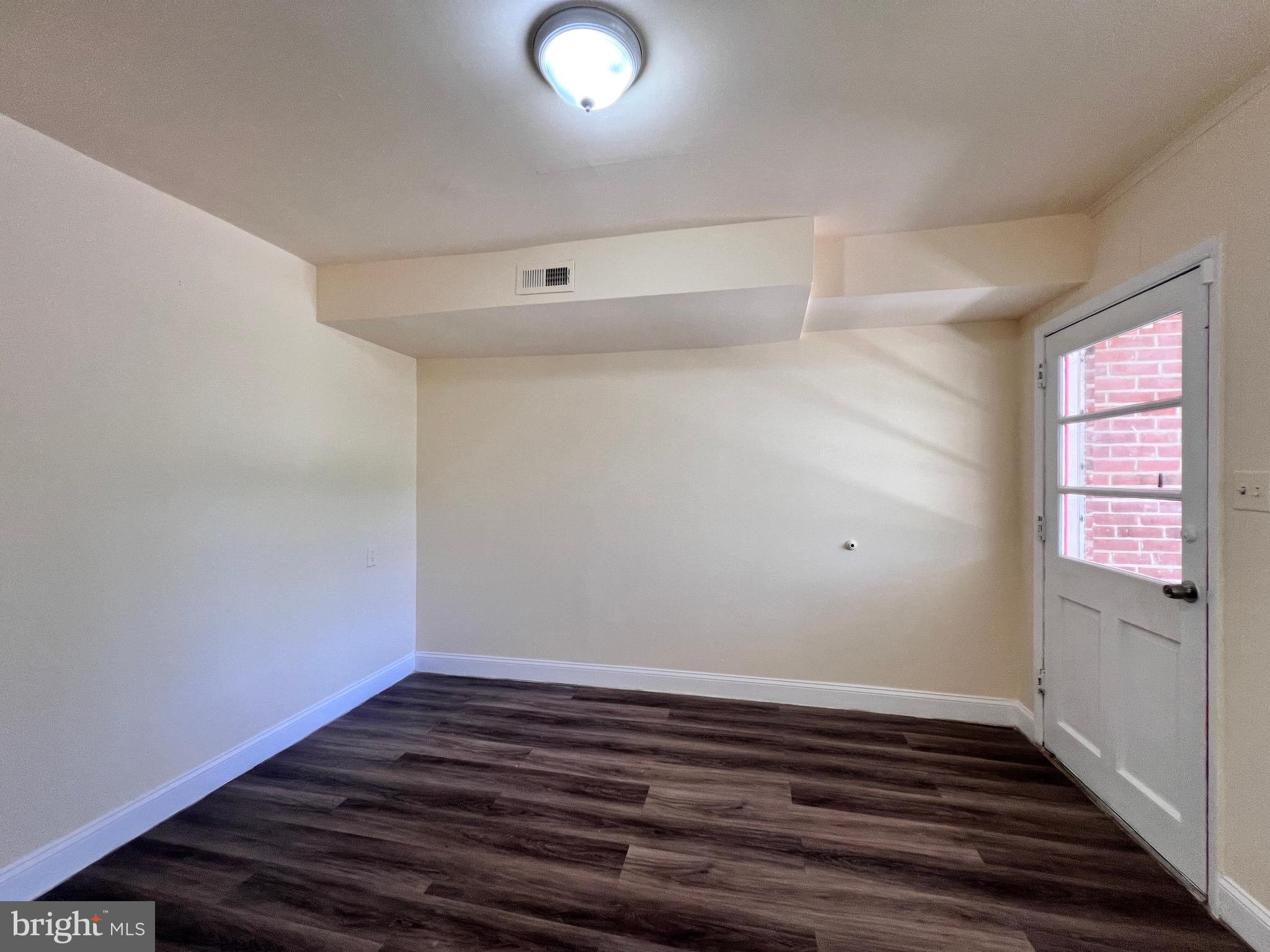 9227 Riggs Road Adelphi, MD 20783 - Photo 52 of 78 a view of an empty room with wooden floor and a window