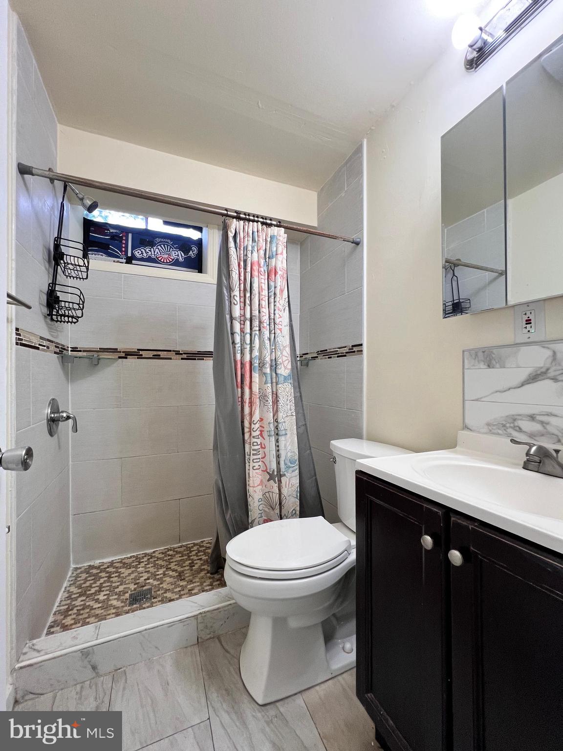 9227 Riggs Road Adelphi, MD 20783 - Photo 64 of 78 a bathroom with a granite countertop sink toilet and shower