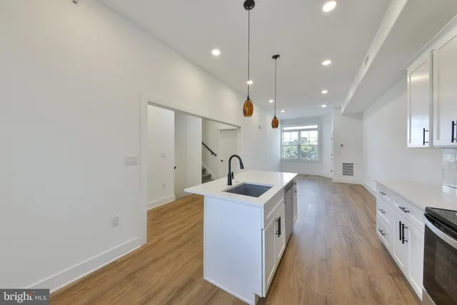 a kitchen with a sink stove and wooden floor
